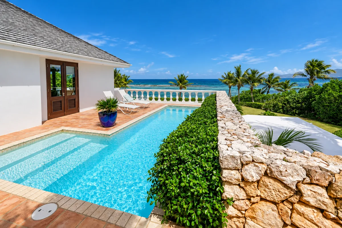 Private villa pool beside a stone wall overlooking the sea in Anguilla